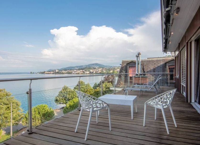 La Rouvenaz in Montreux terrace with lake view, white chairs and table under blue sky