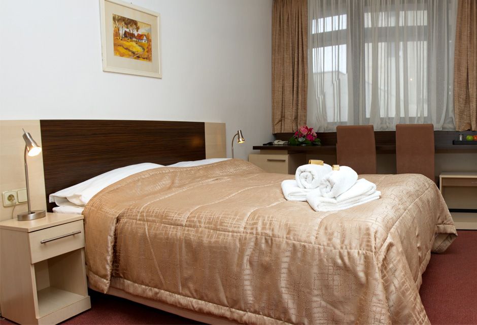 Hotel Expo in Bratislava guest room with double bed, bedside lamps, desk, and window seating area