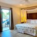 Hotel Playa La Media Luna bedroom on Isla Mujeres with canopy bed and patio doors to a tropical view