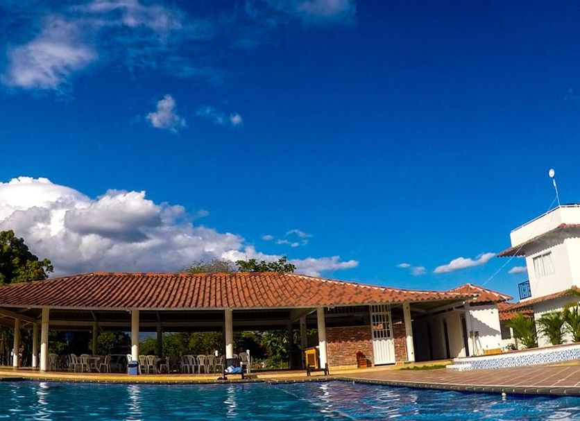 Hotel Campestre Mastranto in Villavicencio with outdoor pool and tiled-roof pavilion under a blue sky.
