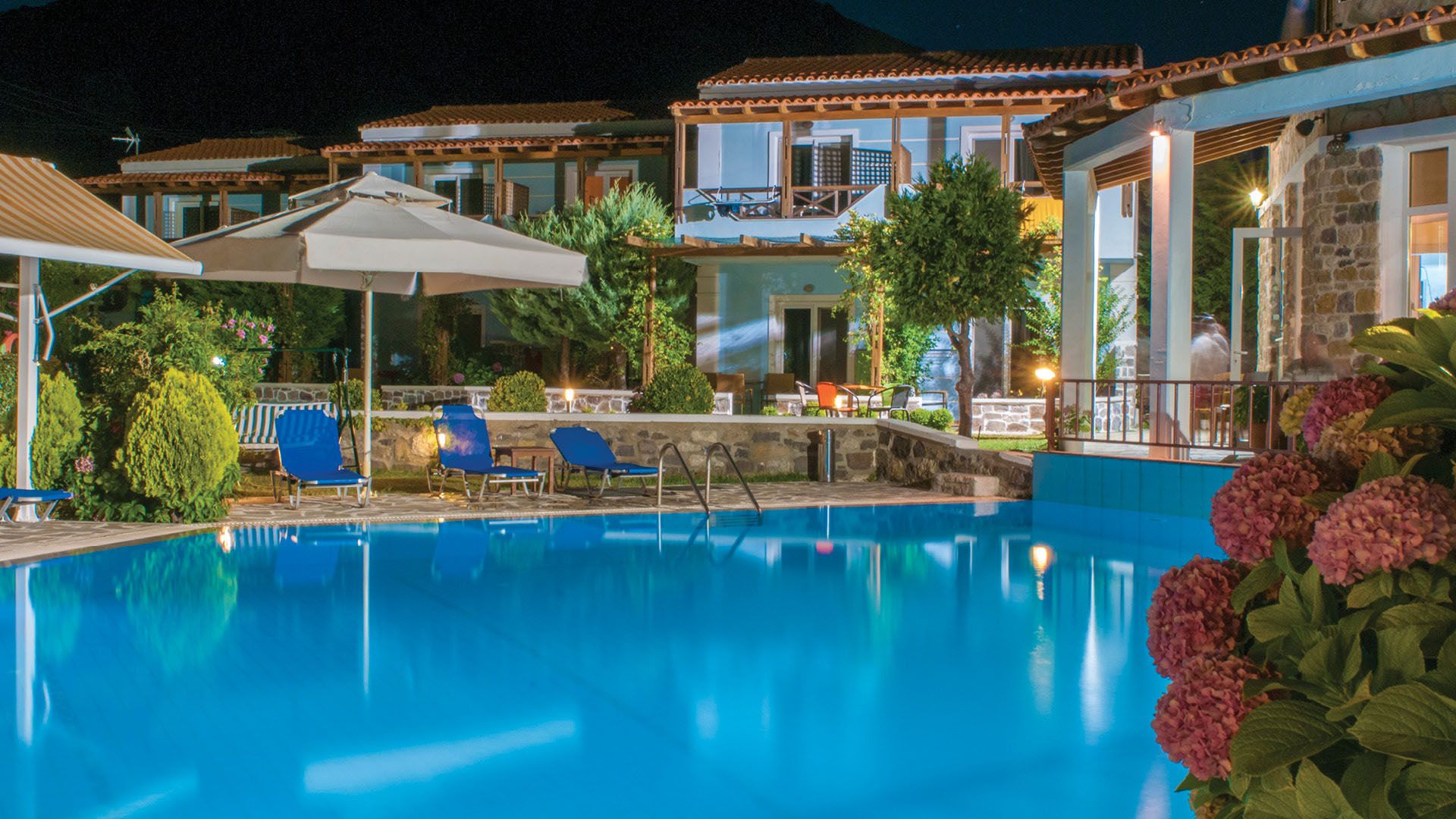 Samothraki Village Hotel in Samothraki with a lit outdoor pool, loungers and terrace seating