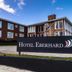 Hotel Capitan Eberhard in Puerto Natales with a roadside sign and brick hotel building under blue sky