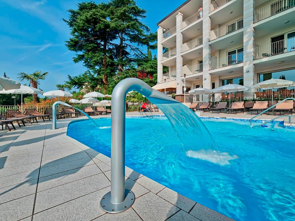 Excelsior Le Terrazze in Garda: outdoor pool with water feature beside balconies and loungers