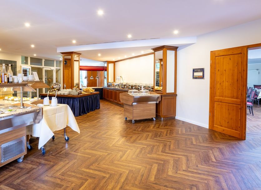 Hotel Döllnsee-Schorfheide in Templin: bright buffet dining room with herringbone wood floor and seating