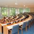Hotel Döllnsee-Schorfheide in Templin conference room with curved rows of desks and blue chairs