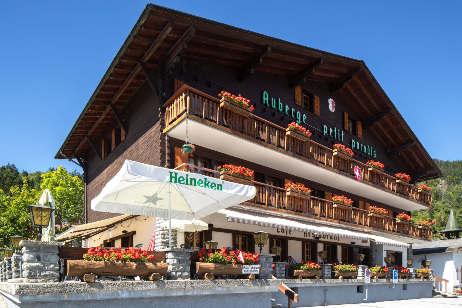 Petit Paradis in Crans-Montana, chalet-style hotel with flower-filled balconies and outdoor terrace