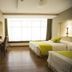 Ramada Hotel in Guayaquil room with two beds, desk, TV, and large window with curtains