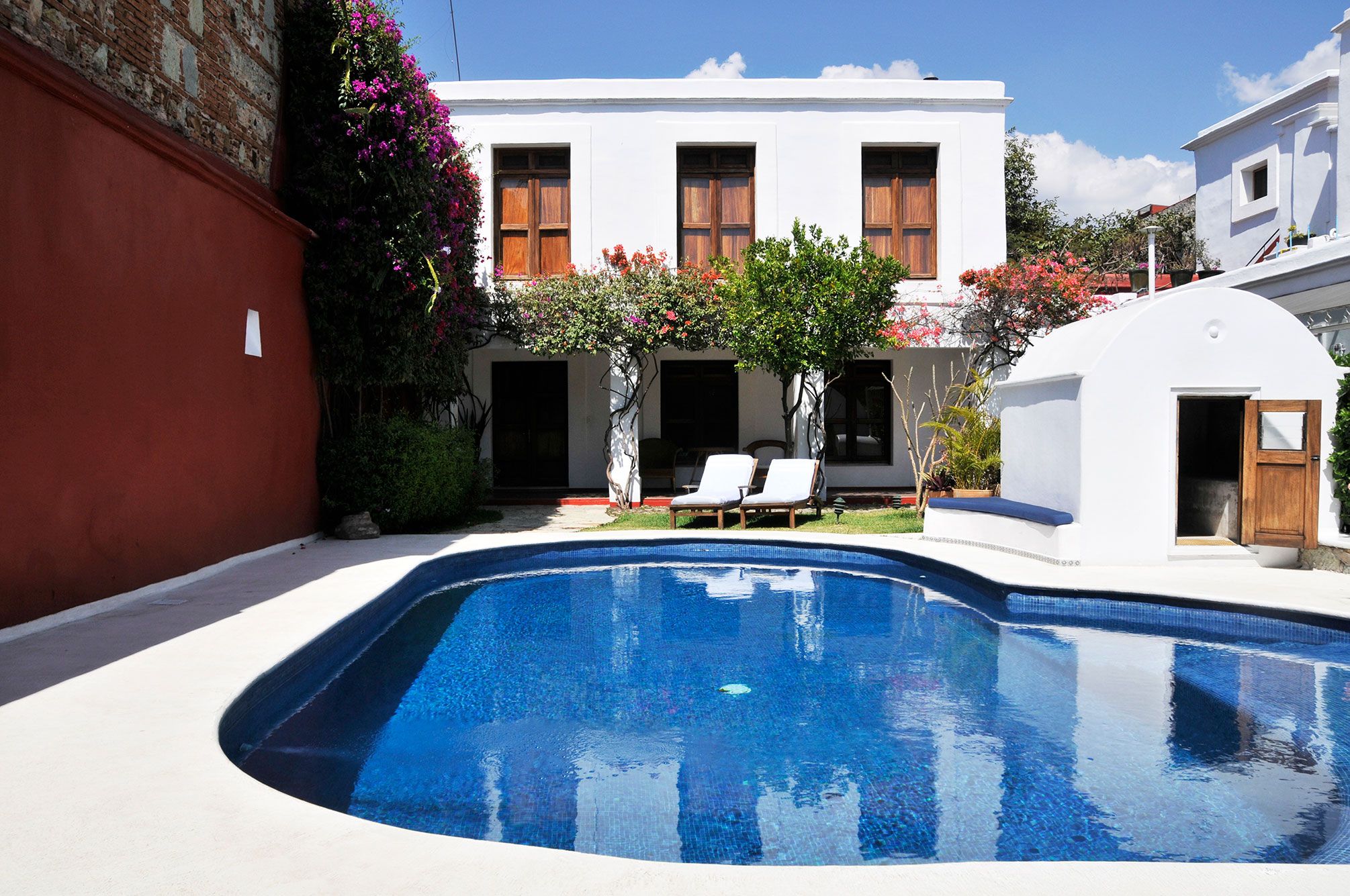Casa Oaxaca in Oaxaca: courtyard pool with lounge chairs and white two-story hotel building