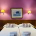 Hotel Don Carmelo in Ávila twin beds with purple wall, framed art and wall lamps