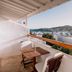 Mykonos Essence Adults Only balcony with seating and city and hillside views in Mykonos