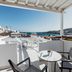 Mykonos Essence Adults Only terrace with sea and Mykonos town views, white chairs and table