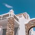 Mykonos Essence Adults Only in Mykonos, stone-arched white hotel entrance against blue sky