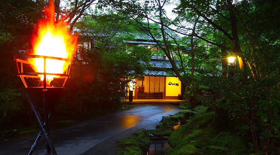 Kurokawaonsen Yamamizuki in Minamioguni with a lit torch by a forest path at night