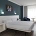 Gran Hotel Regente in Oviedo guest room with double bed, desk, chair, TV and large window