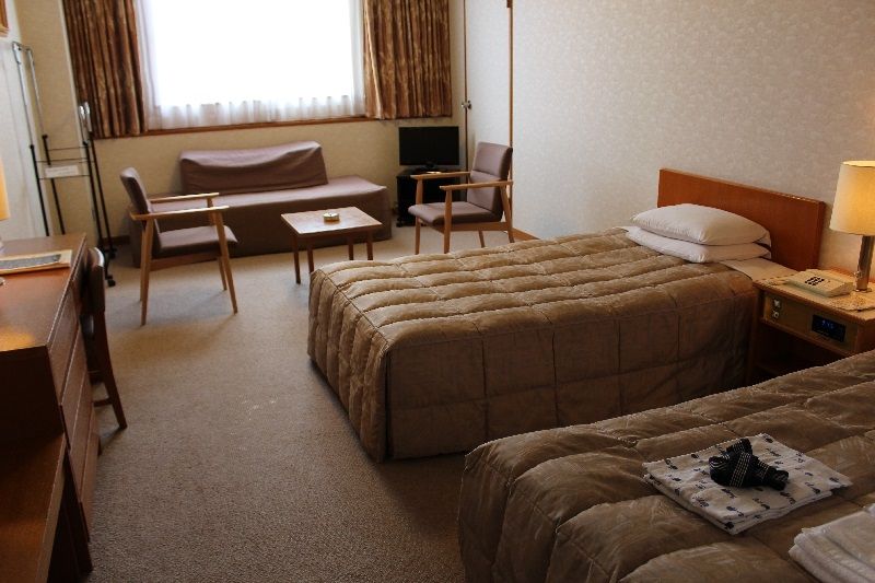 Yuzawa Park Hotel guest room in Yuzawa with two twin beds, seating area and window light