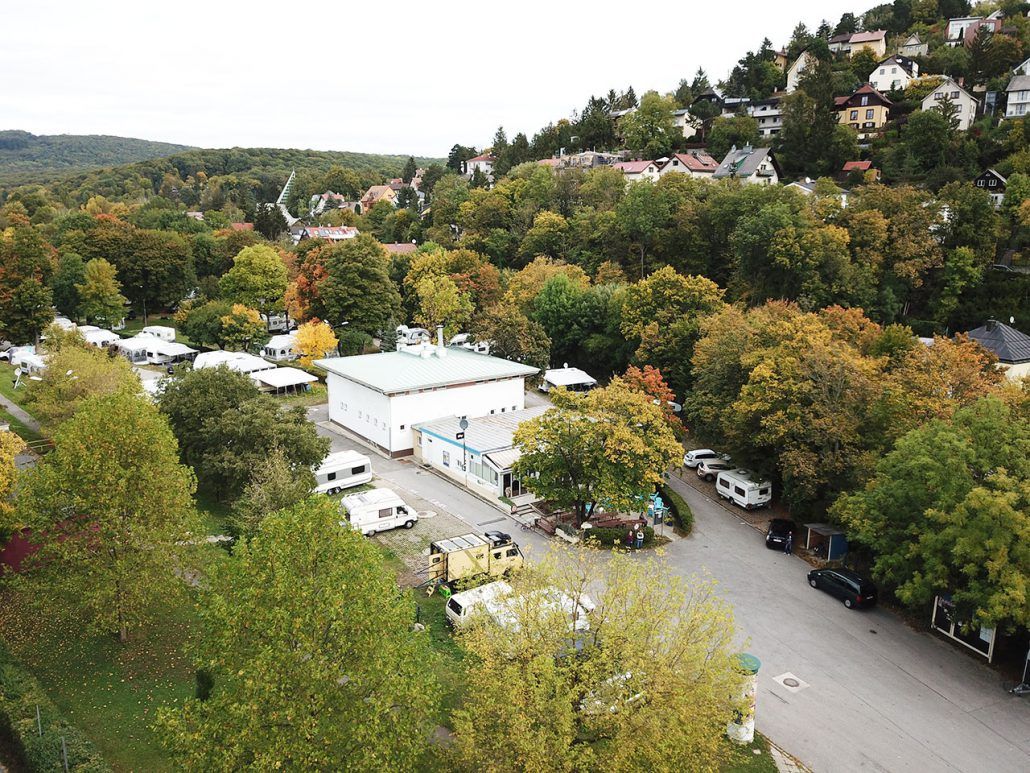 Camping Wien West in Vienna nestled in a wooded hillside with parked caravans and vehicles
