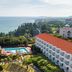 Kensington Resort Jeju Jungmun in Seogwipo with ocean view and outdoor pool beside a red-roofed building