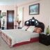 Mansion Giahn Bed & Breakfast in Cancún room with carved headboard, king bed and tall windows