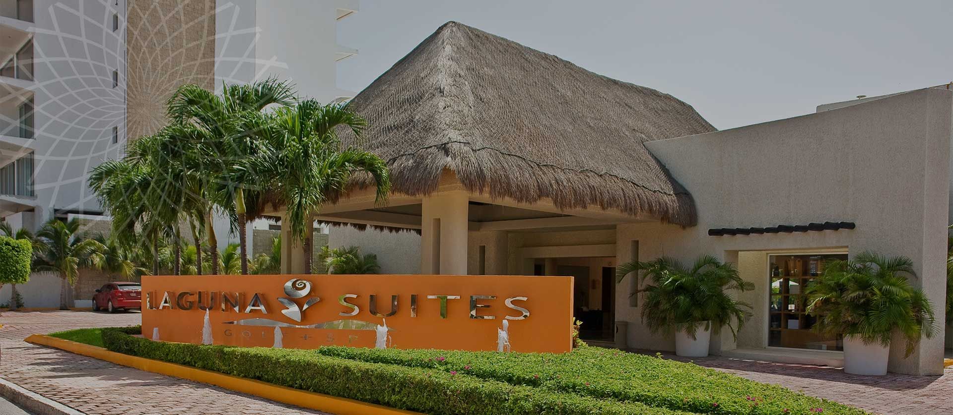Laguna Suites Golf & Spa in Cancún with thatched entrance and landscaped front drive