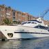 Christina Onassis Yachthotel in Rotterdam beside a docked white yacht and brick waterfront building