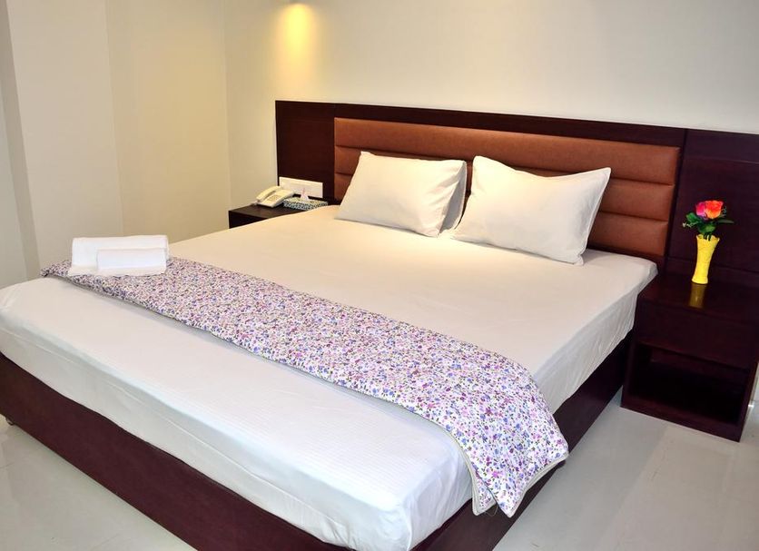 Ocean Palace Cox'sBazar in Cox’s Bāzār: neatly made double bed with bedside lamp and flowers