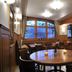 Hôtel Restaurant Cave Bel-Air in Mont-Vully dining room with round tables, wood paneling, and large windows
