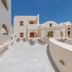 Epavlis Hotel & Spa in Kamari: sunlit rooftop terrace with lounge chairs and white Cycladic architecture