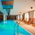 Garden Toscana Resort in San Vincenzo indoor pool with orange lounge chairs and natural light
