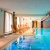 Indoor pool at Garden Toscana Resort in San Vincenzo with lounge chairs and floor-to-ceiling windows