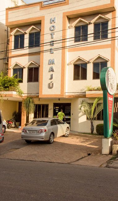 Hotel Maju in Rio Branco exterior with parked cars and balcony-style windows