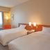 Mutsu Grand Hotel in Mutsu guest room with two twin beds, orange chairs, and window light