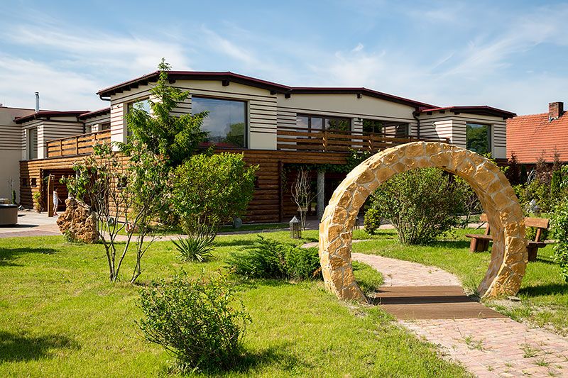 Sommer Residence Hotel&Spa in Kluczbork with a stone archway and landscaped garden outside the hotel