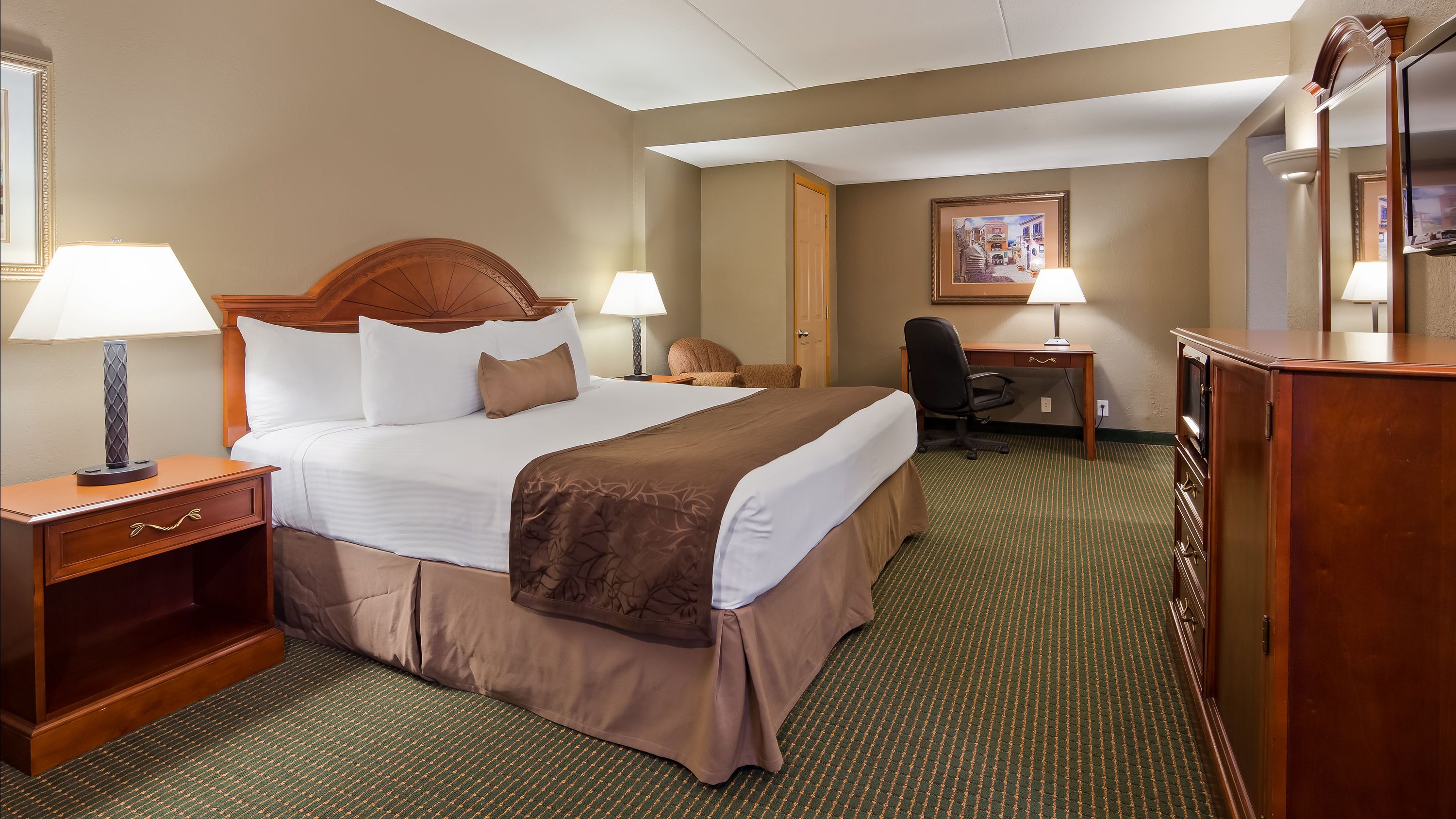 Best Western Plus Longbranch Hotel & Convention Center room in Cedar Rapids with king bed, desk and lamps