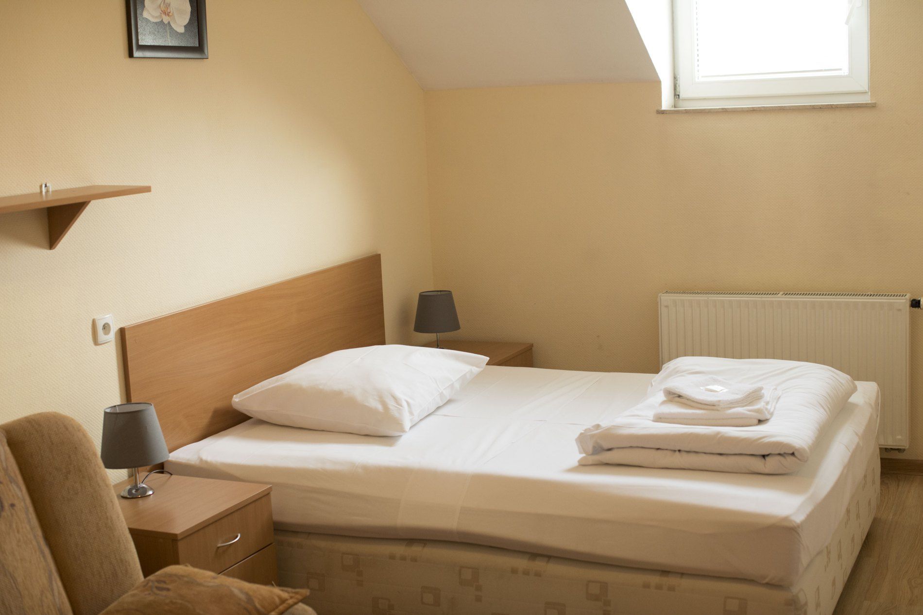 Hotel 7 in Szczecin guest room with double bed, bedside lamps, and skylight window