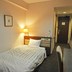 The Canaan Hotel in Tokyo guest room with a single bed, desk and hallway view
