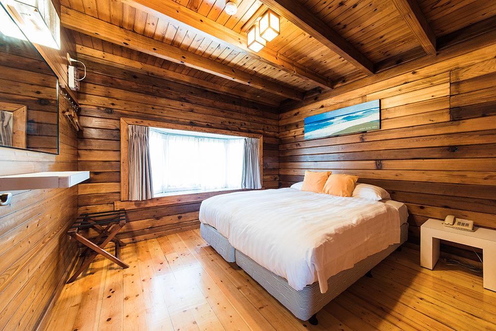 Kentington Resort in Manzhou Township guest room with wood walls, king bed, and large window