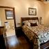 The Thornton Inn Bed and Breakfast in Arlington, bedroom with patterned bedspread, bathroom doorway, and window