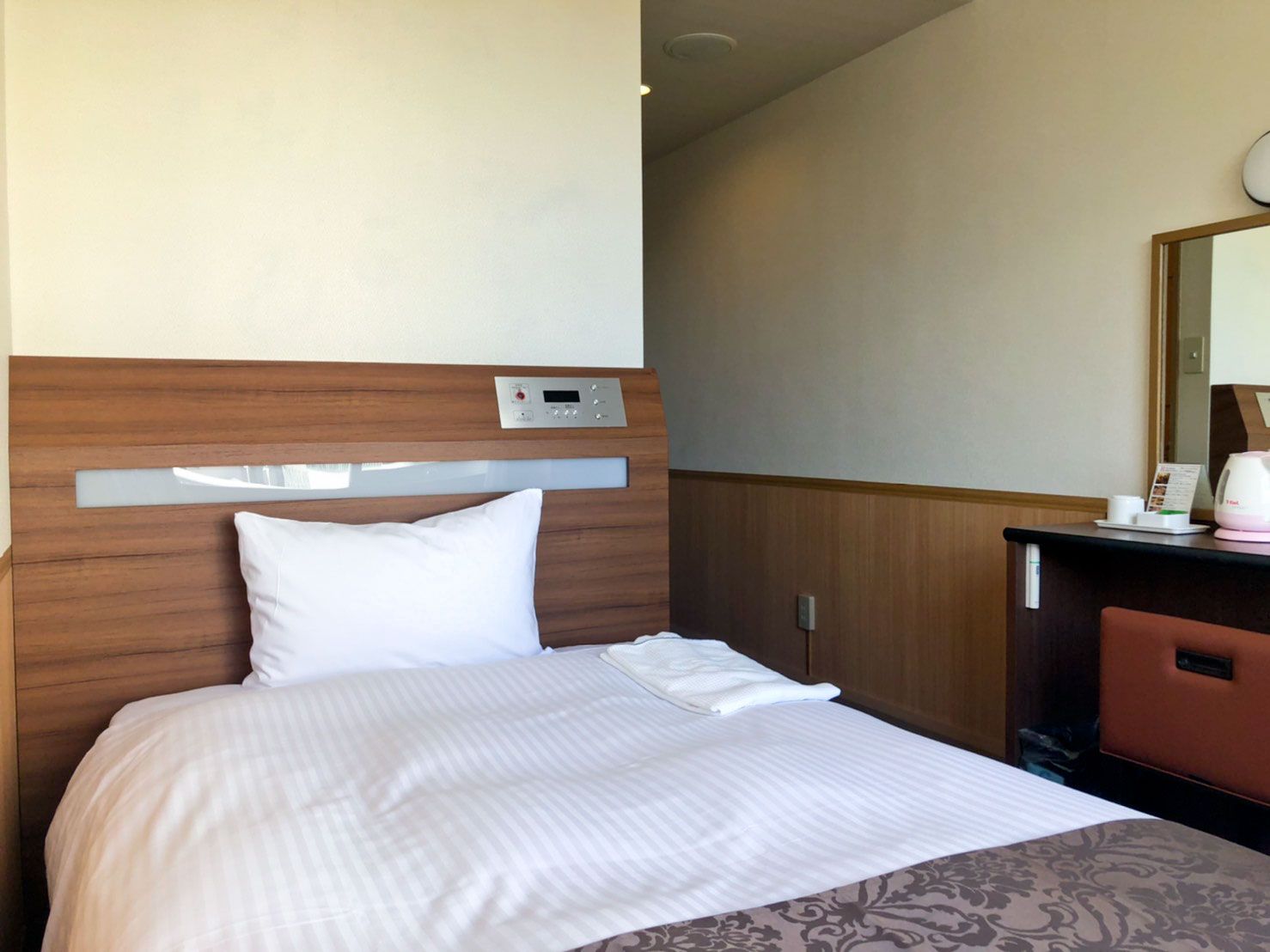 Chabira Hotel Naha in Naha, simple single bed room with wood-paneled headboard and desk
