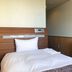 Chabira Hotel Naha in Naha, simple single bed room with wood-paneled headboard and desk