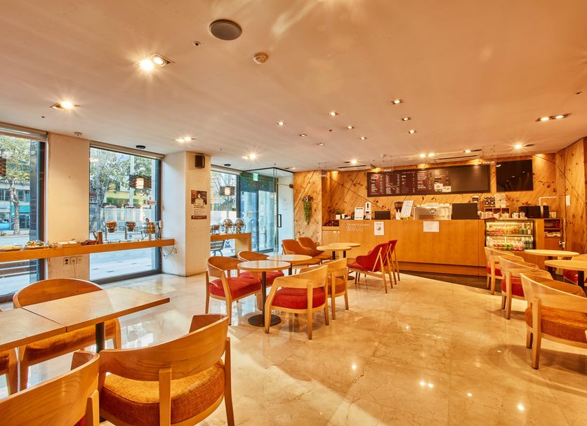 Provista Hotel Gangnam in Seoul lobby café with wooden tables, chairs, and large windows