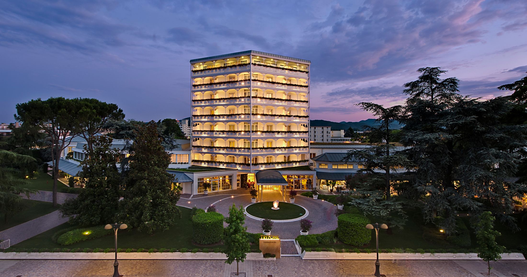 Tritone Luxury Hotel Thermae & Spa in Abano Terme, illuminated tower hotel with garden and circular fountain
