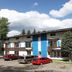 St Moritz Lodge and Condominiums in Aspen with mountain-style exterior, parked cars, and trees
