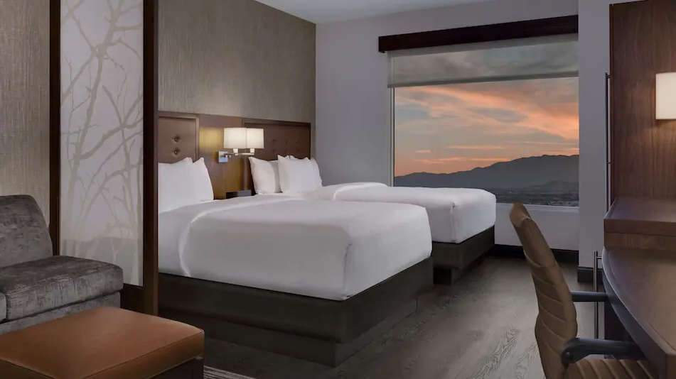 Hyatt Place Las Vegas at Silverton Village guest room with two beds and a large desert sunset view