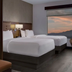 Hyatt Place Las Vegas at Silverton Village guest room with two beds and a large desert sunset view