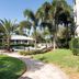 Trianon Bonita Bay Hotel in Bonita Springs with palm-lined garden path, pool, and lush landscaping