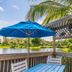 Trianon Bonita Bay Hotel in Bonita Springs: tropical deck with lake view, blue umbrella and palm trees