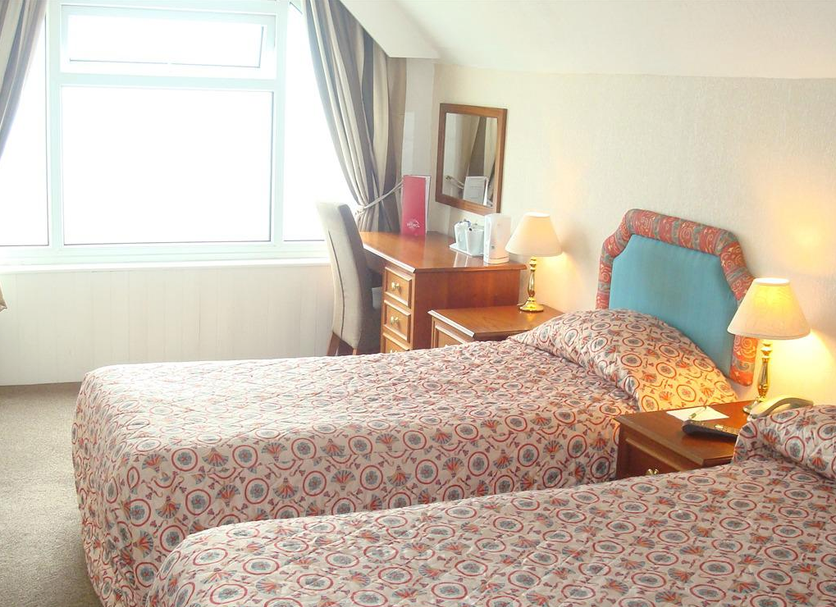 The Hydro Hotel, Douglas twin room with two single beds, window, desk and bedside lamps