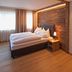 Pfefferkorn's Hotel in Lech am Arlberg: cozy double room with wood-paneled wall and bedside lamp