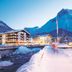 Pfefferkorn's Hotel in Lech am Arlberg beside a snowy river and mountain at dusk