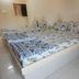 Vrp Guest House in Bhuj, simple twin bed room with patterned bedding and tiled floor.